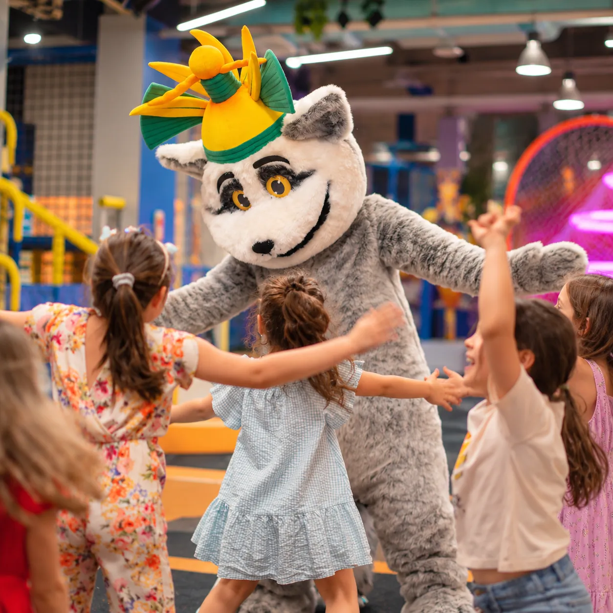Mascota lemur cu coroană dansând cu fetițele în zona de joacă KLANkids Adventure