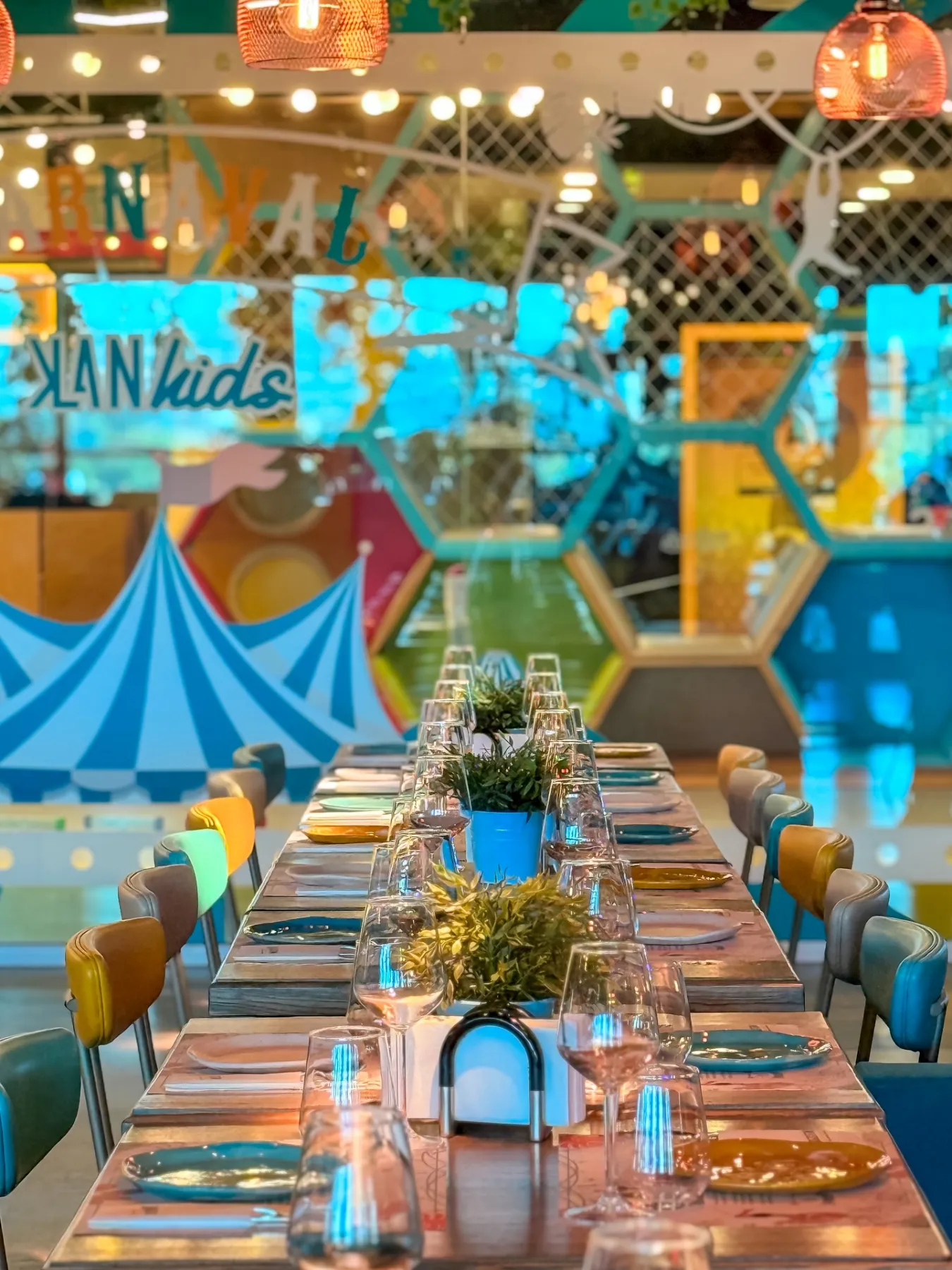 Masă lungă aranjată în restaurantul KLANdestin, cu vedere spre zona de joacă KLANkids Carnaval